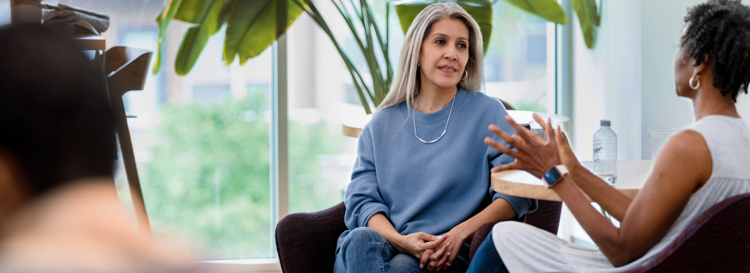 An adult woman meets with her counselor in a professional setting.