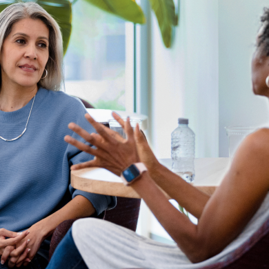 An adult woman meets with her counselor in a professional setting.