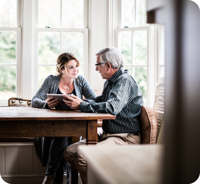 A adult male counselor and his client meet and review progress on a tablet device. 