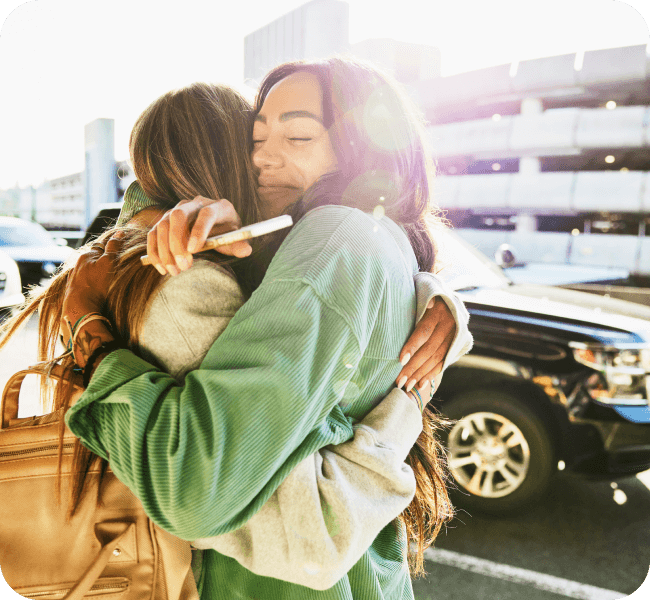 Two women share a close and personal embrace in the sunshine.